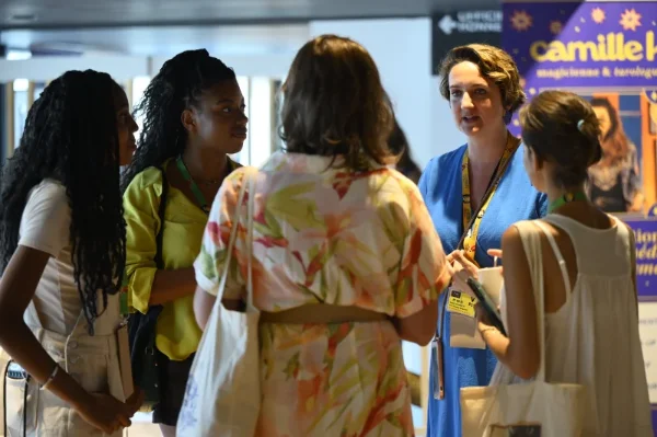 Visiteuses discutant avec une exposante sur un stand