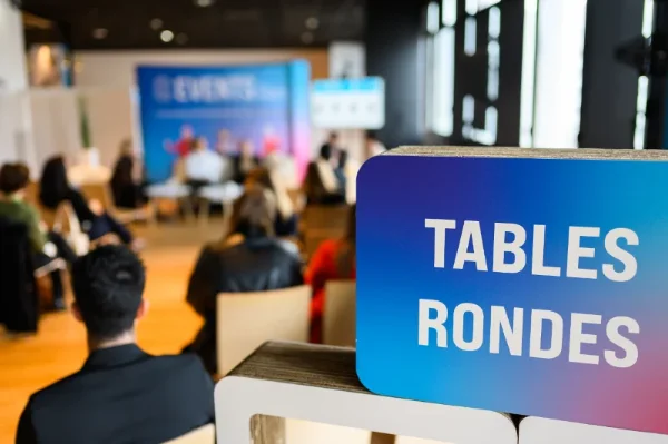 Panneau « Tables rondes » devant un espace de conférence